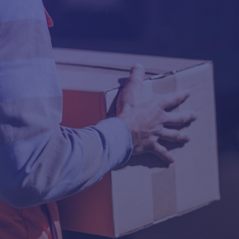 Delivery driver carrying a cardboard box for last mile delivery