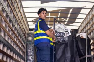 Aria Logistics driver loading garments inside delivery truck for New York Fashion Week 2025